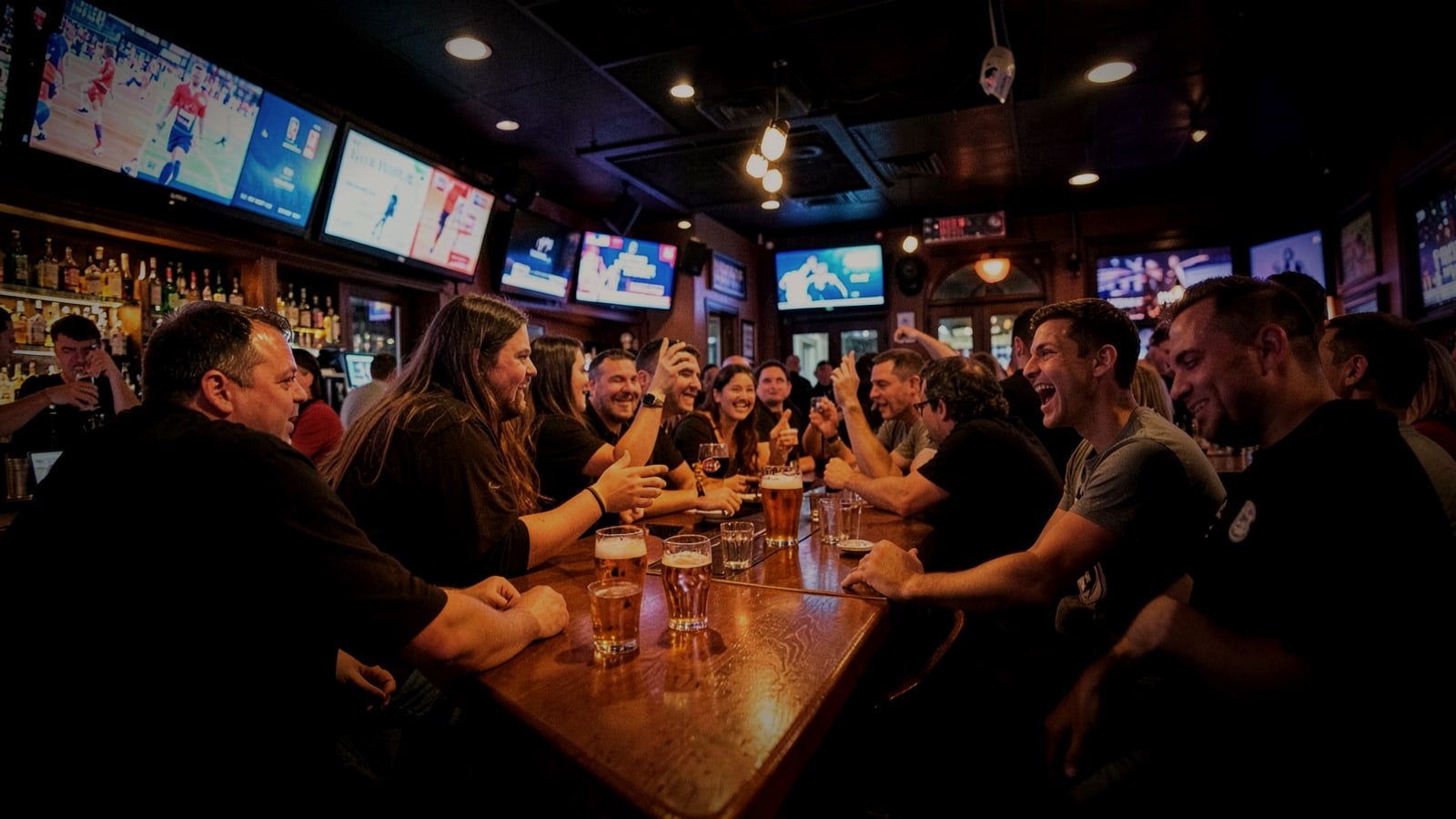 Fans cheering at the counter of a lively sports bar